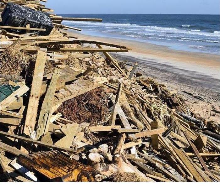 Storm damaged boards are shown on a beach