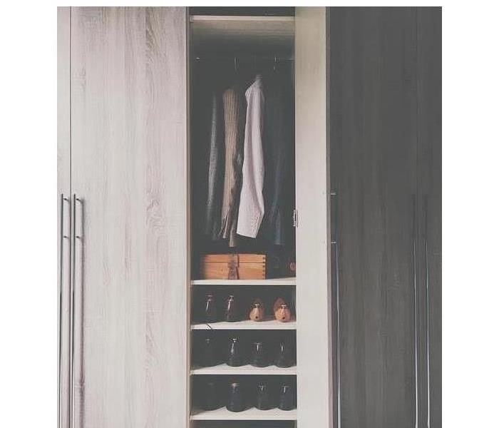 A closet is shown with jackets and shoes