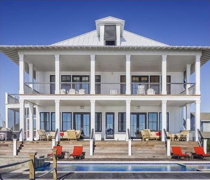 A white two story beach house is shown