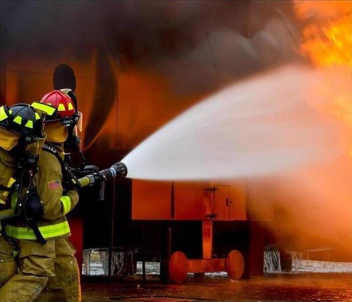 A firefighter is shown using a hose to put out a fire